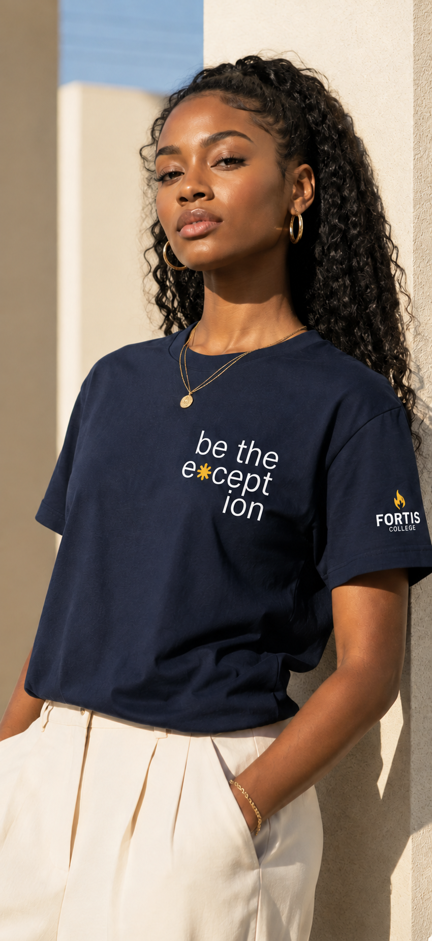 Woman wearing a navy Campus Supply Be the Exception T-shirt in warm architectural light